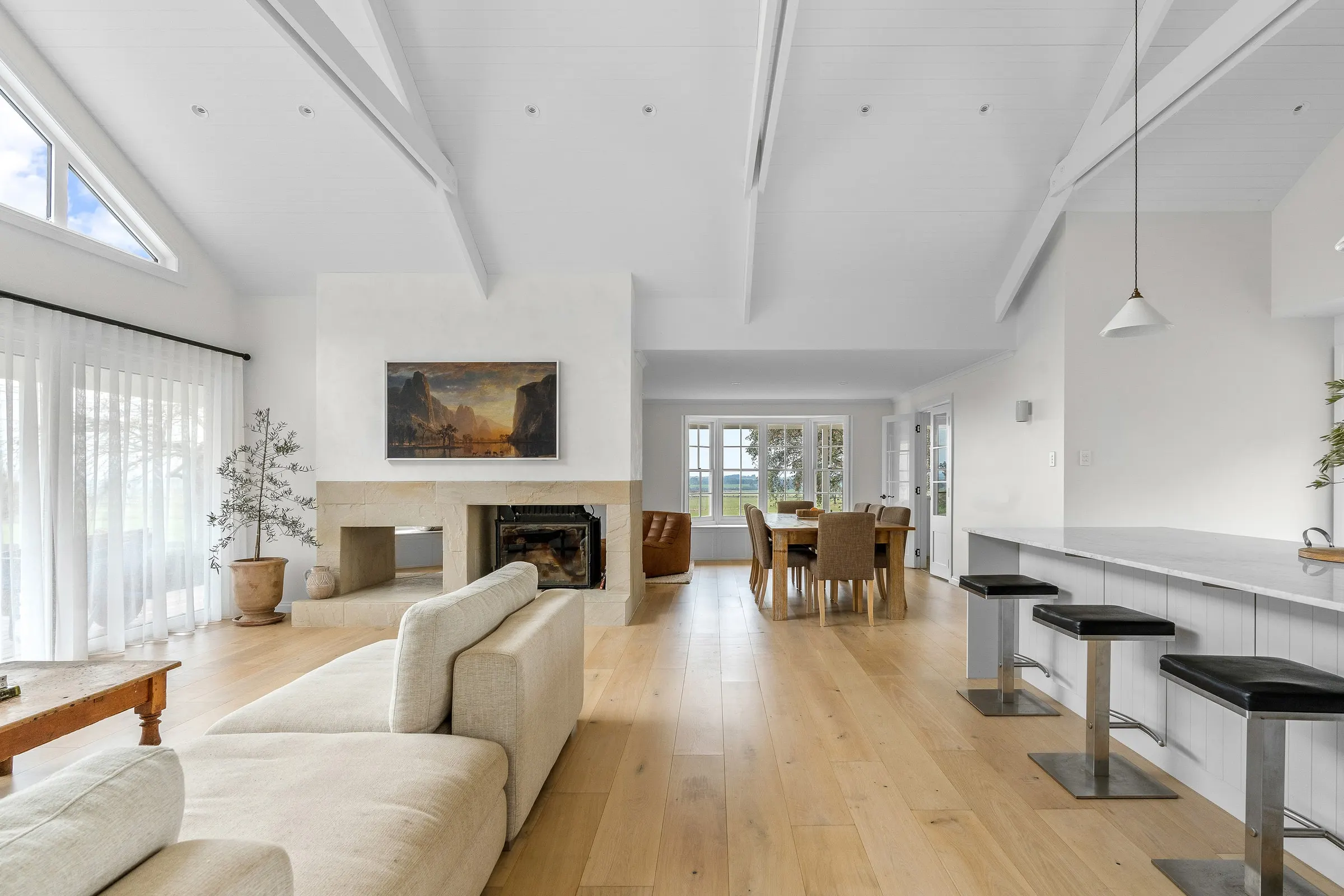 A finished living room with a raked white ceiling, fireplace and oak floor, Hagley
