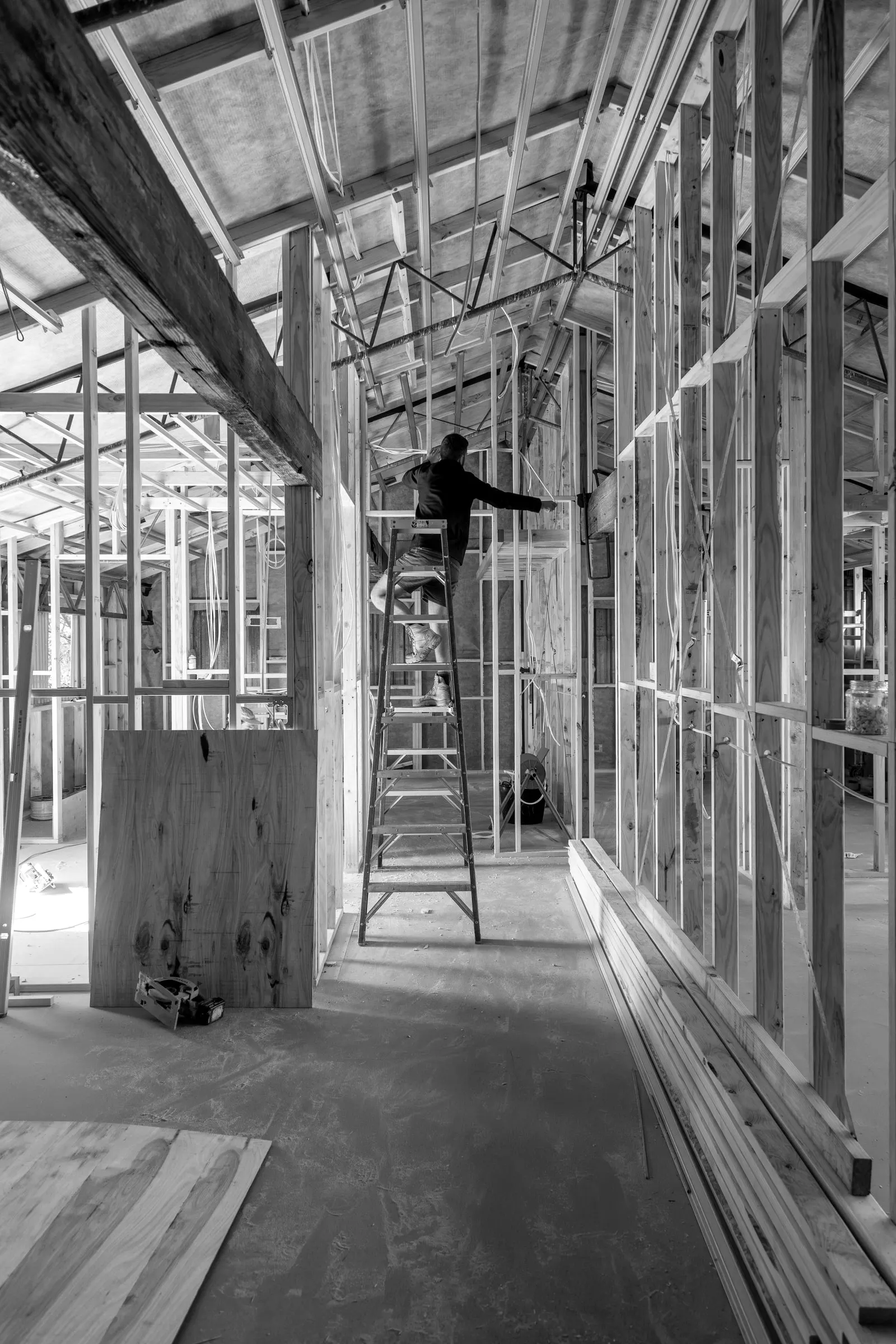 A carpenter on a ladder working inside the timber frame, Relbia