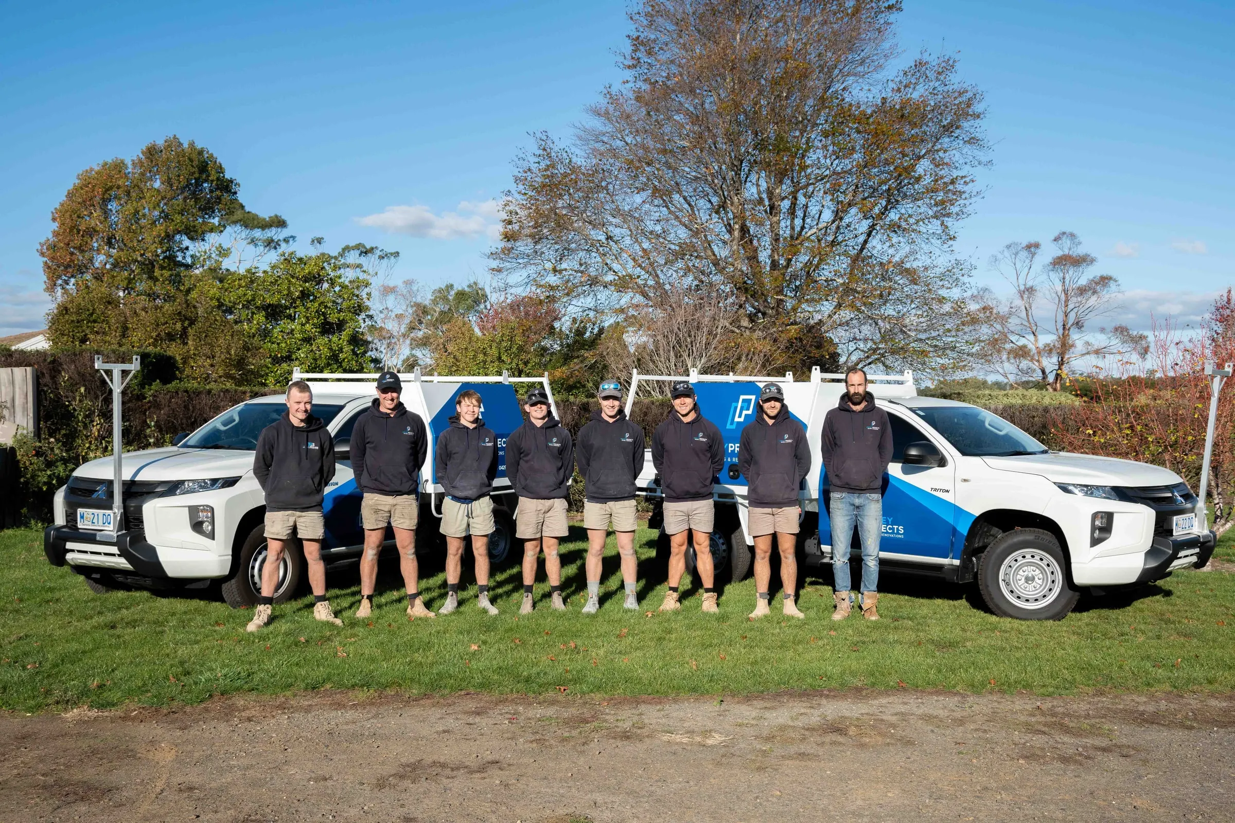 The Pedley Projects team standing together beside their utes